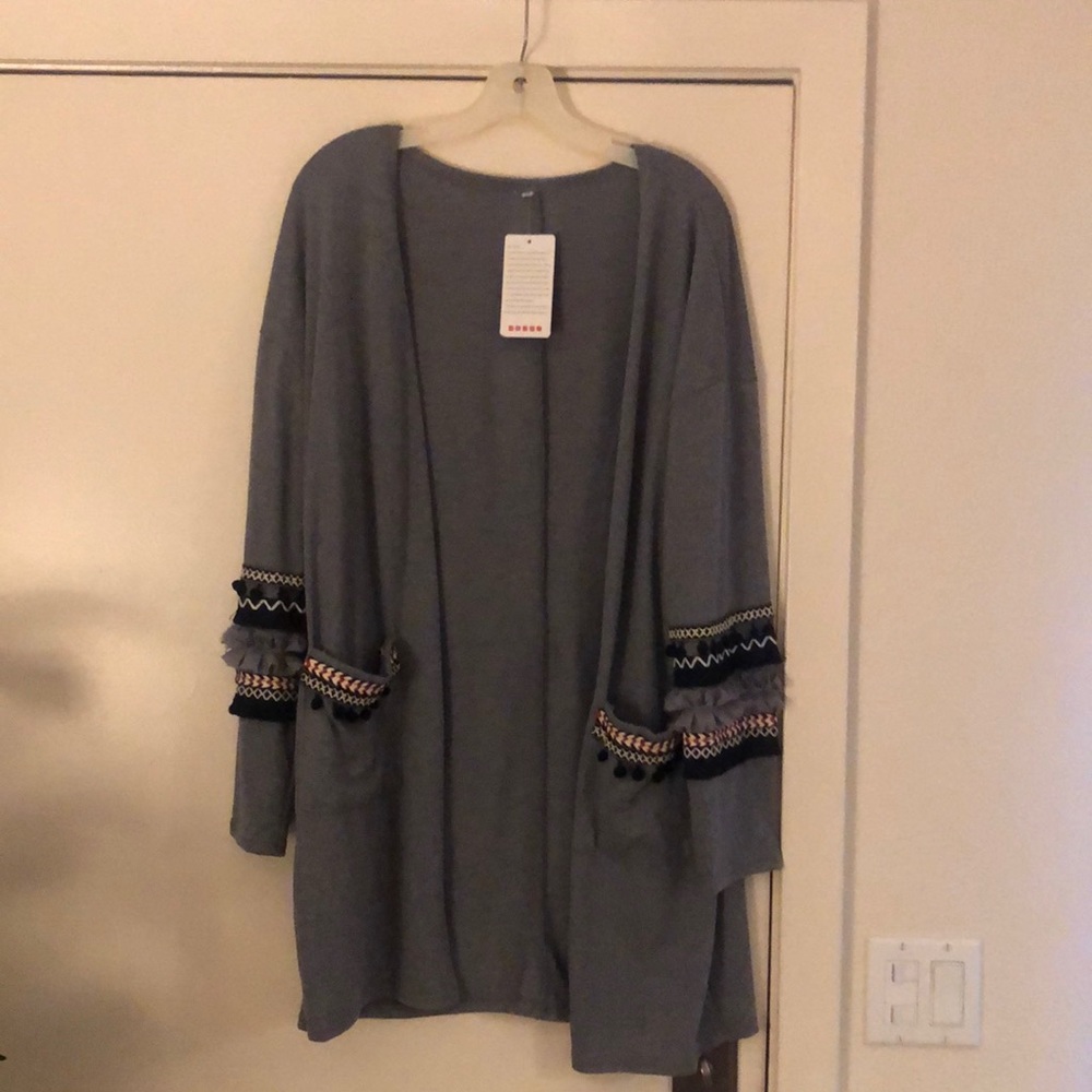 Grey cardigan with ruffles and ball accents